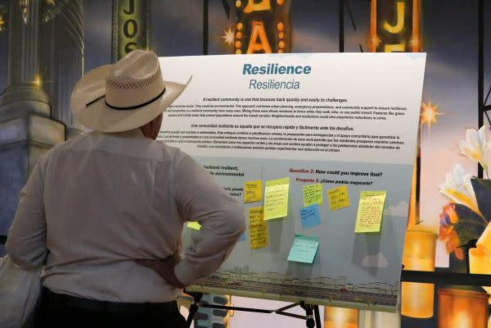 San Antonio resident Jack Finger, wearing a cowboy hat, examines the principle of resiliency for the upcoming transit oriented development policy