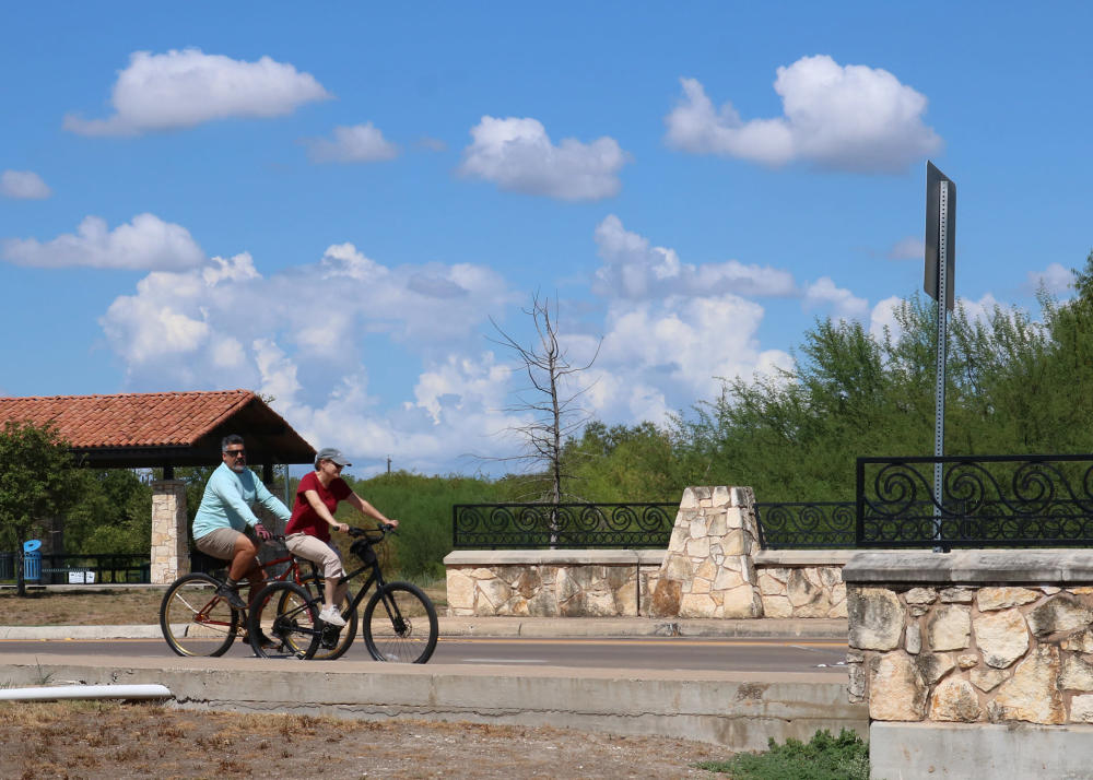 two bicyclists endure the summer heat in the bike lanes of woodlawn lake