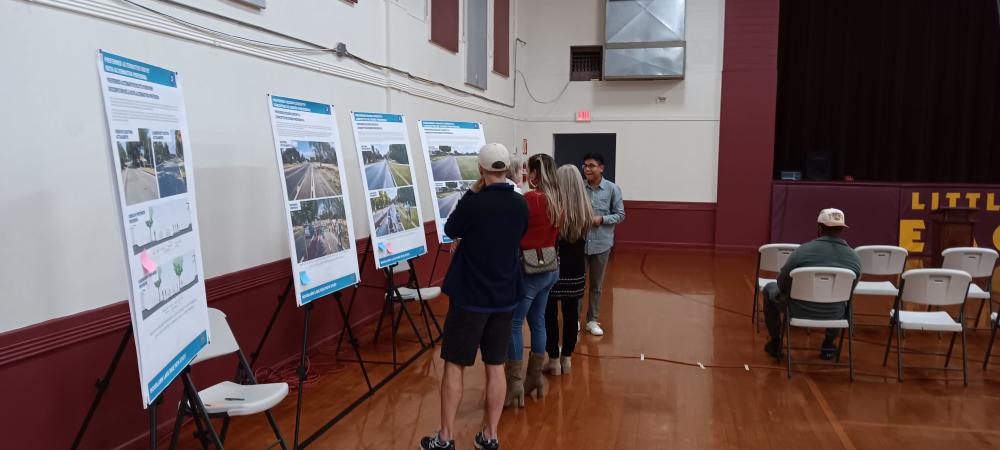 a group of interested woodlawn lake residents examine the various designs being offered for bike lane improvements.